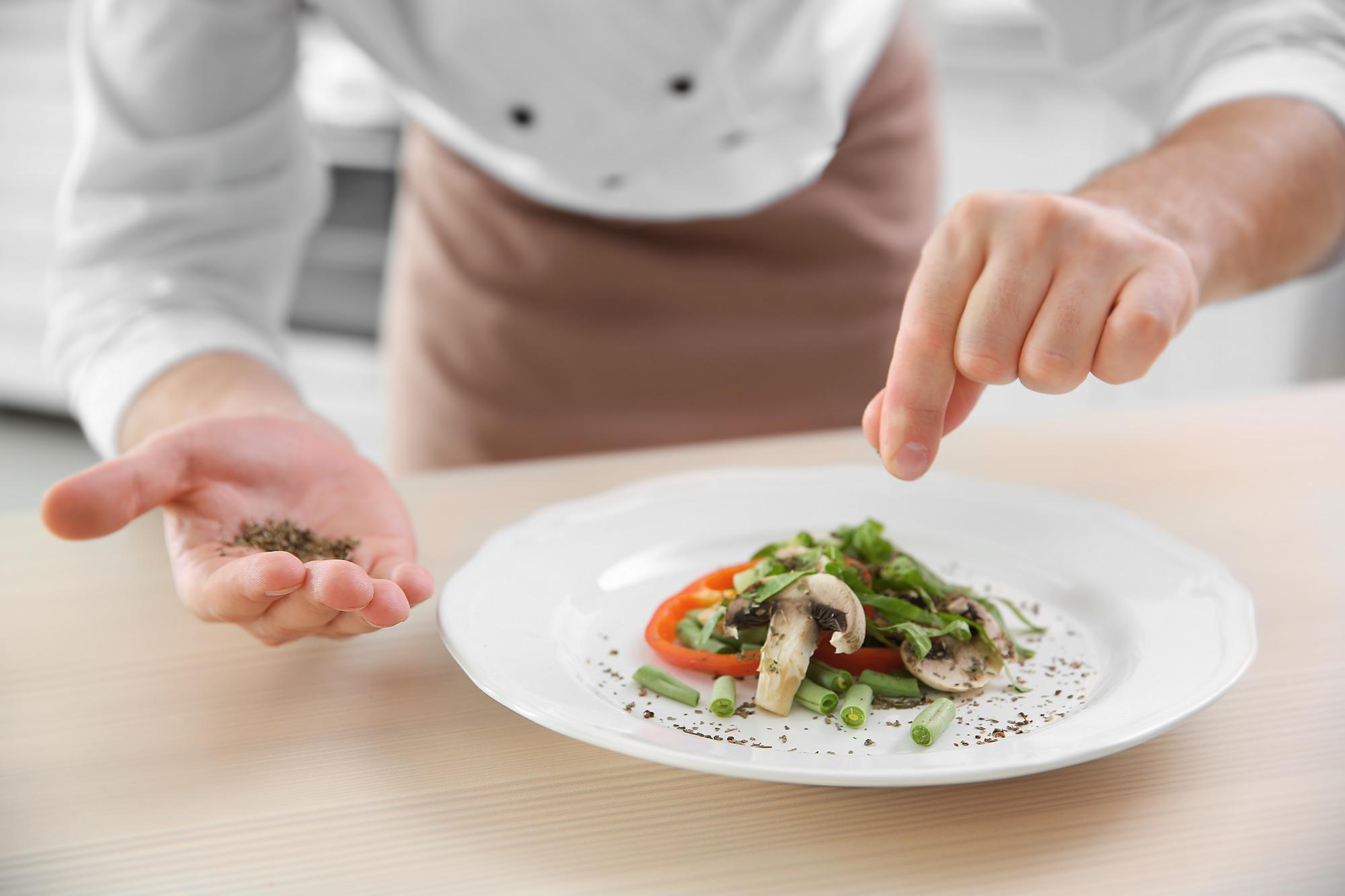 chef arranging plated meal on counter